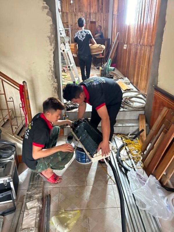 Kỹ thuật viên kiểm tra cục nóng quạt và máy nén điều hòa